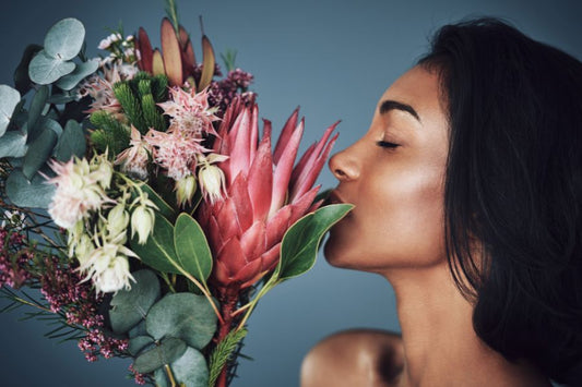a woman smells a floral arrangement